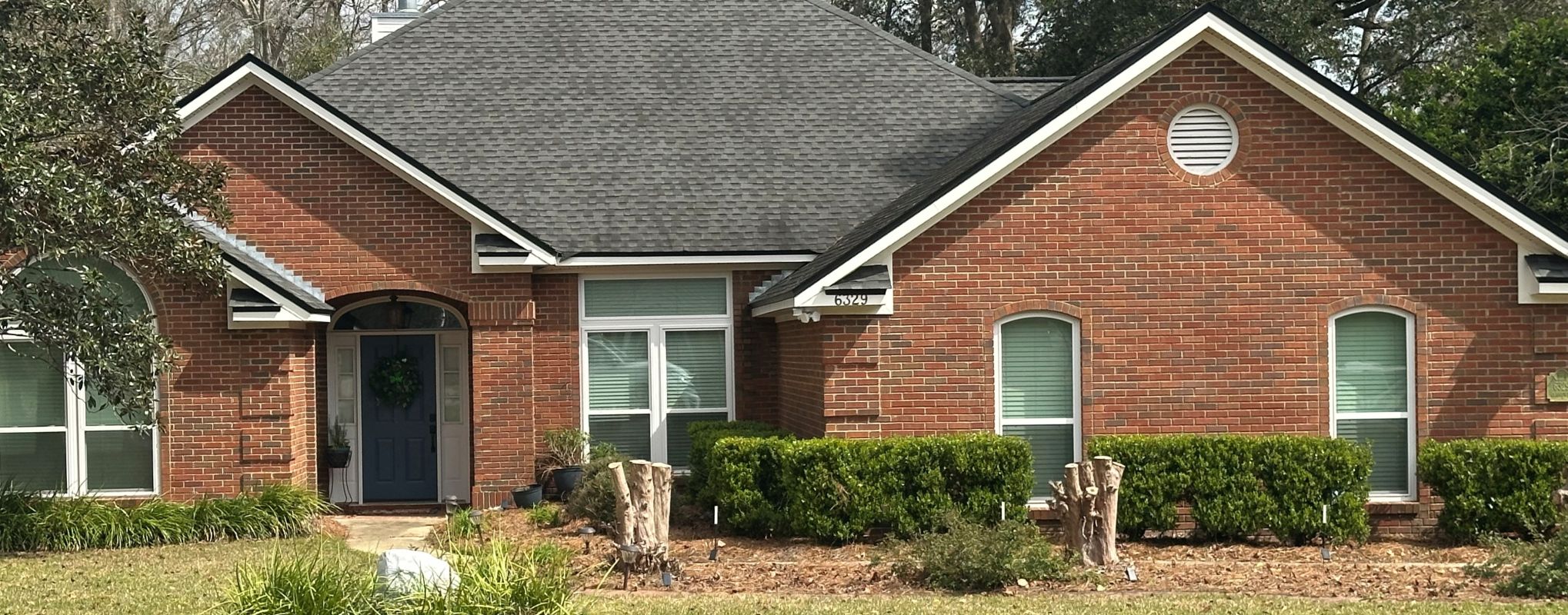 White windows with special shapes and transom in medium brown brick