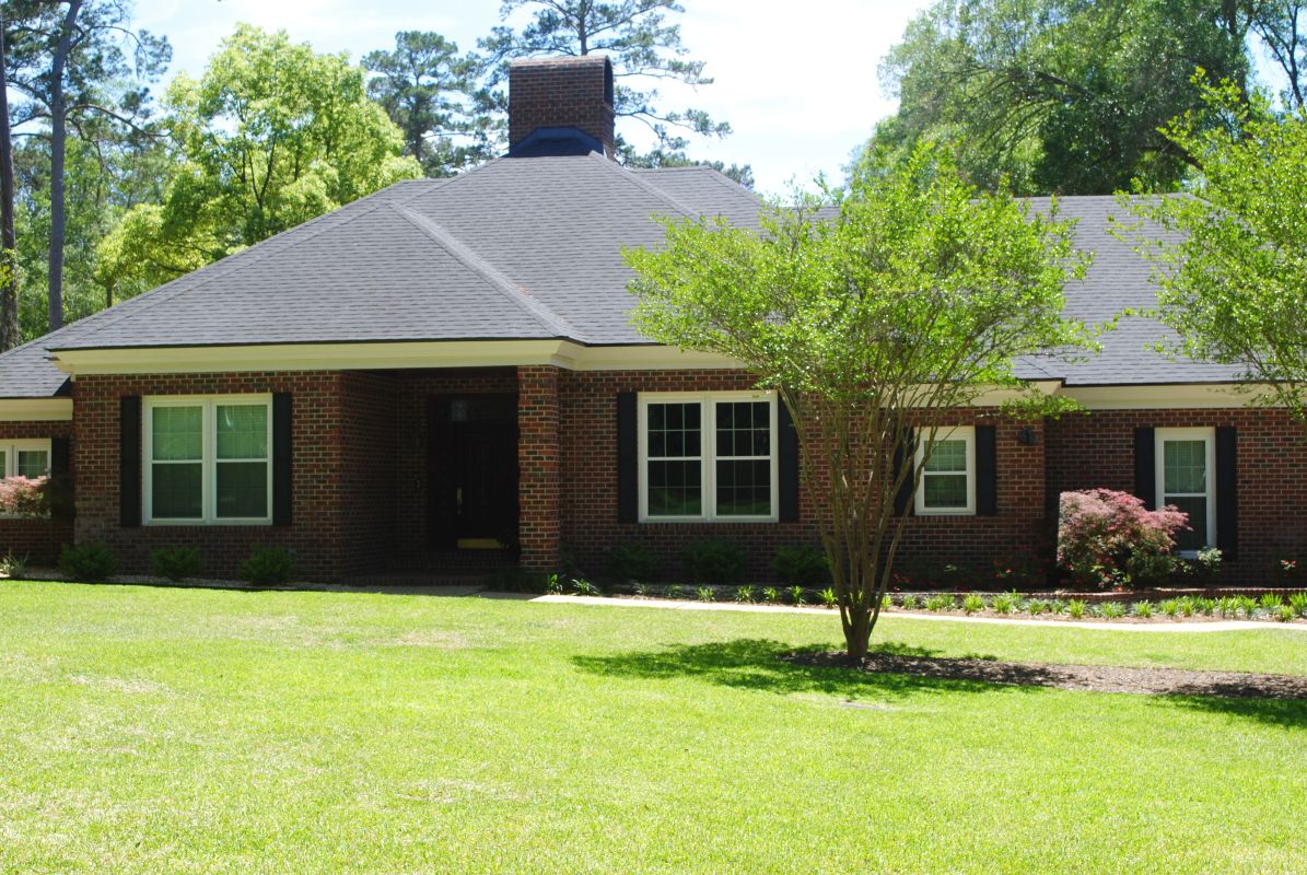 White windows in dark brick with black shutters