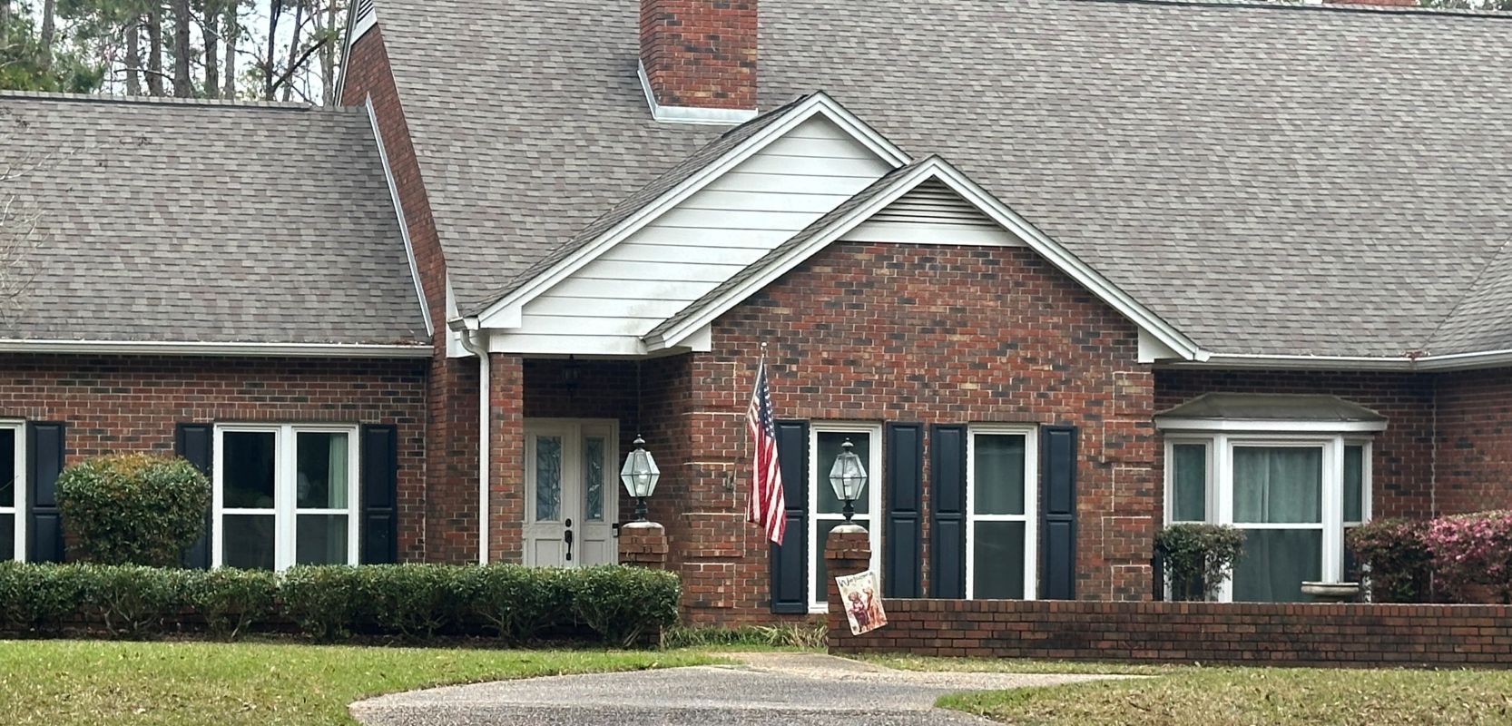 White windows in dark brick with bay