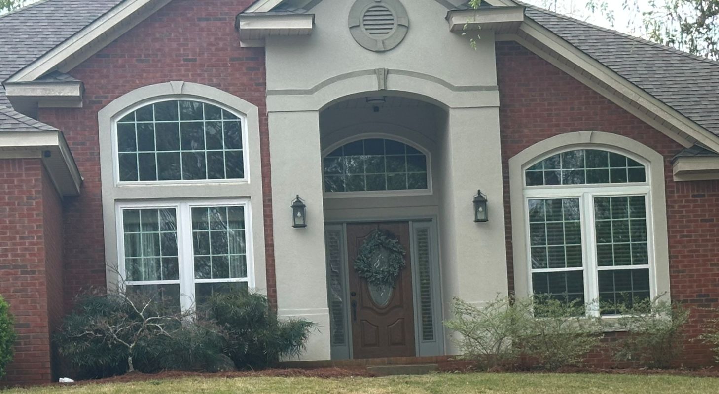 White windows with colonial grids in dark brick and stucco bands